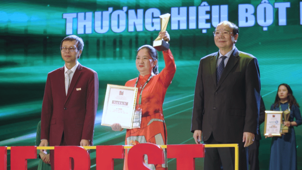 Founder NAVAN Nguyễn Thị Kiều Trang giơ cao cup và bằng khen TOP 5 Thương hiệu Ngũ cốc chất lượng tốt nhất Việt Nam 2025 tại sự kiện The Best of Vietnam